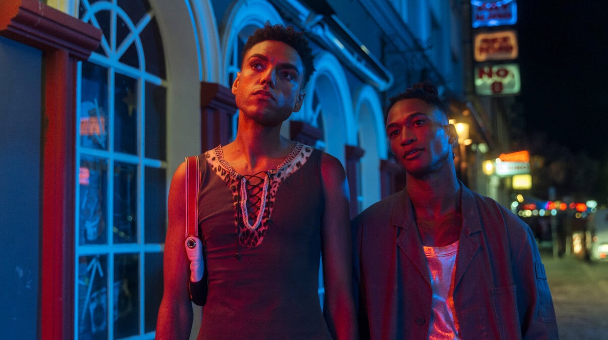 TV & Streaming Tipps Oktober: Zwei Männer in einen neobeleuchten Straße bei Nacht