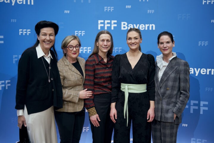 FFF Empfang auf der Berlinale (c) Bayerische Staatskanzlei – Henning Schacht Fünf Frauen stehen vor einer blauen Pressewand. Auf dieser Pressewand steht mehrfach in mehreren Schriftgrößen und -intensitäten FFF Bayern. Alle Frauen lächen in die Kamera.