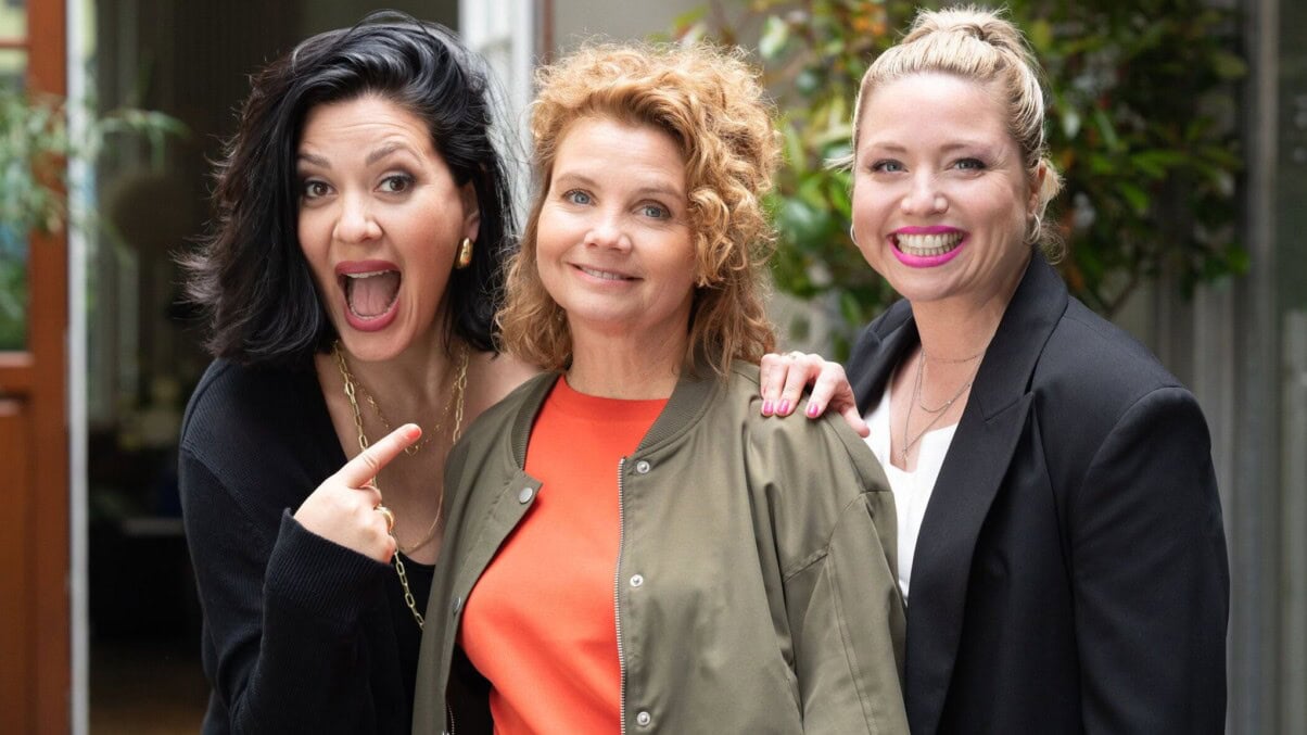 Frier & 50_c_Joyn_Michael_Kötschau TV & Streaming Tipps November: Drei Frauen stehen lachend nebeneinander und schauen in die Kamera; eine von ihnen zeigt mit einem Finger auf die Frau in der Mitte, alle wirken fröhlich und energiegeladen.