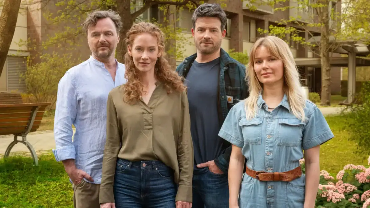 Spreewaldklinik, Staffel 2 (c) Sat.1 / Hardy Spitz TV & Streaming Tipps im Juli 2025: Vier Personen stehen in einem Garten vor einer Klinik. Die Klinik hat braune Ziegelsteine und beige Balkonelemente. Die vier Personen sind zwei Männer und zwei Frauen mittleren Alters in Straßenkleidung. Sie blicken direkt in die Kamera und sehen zufrieden aus.