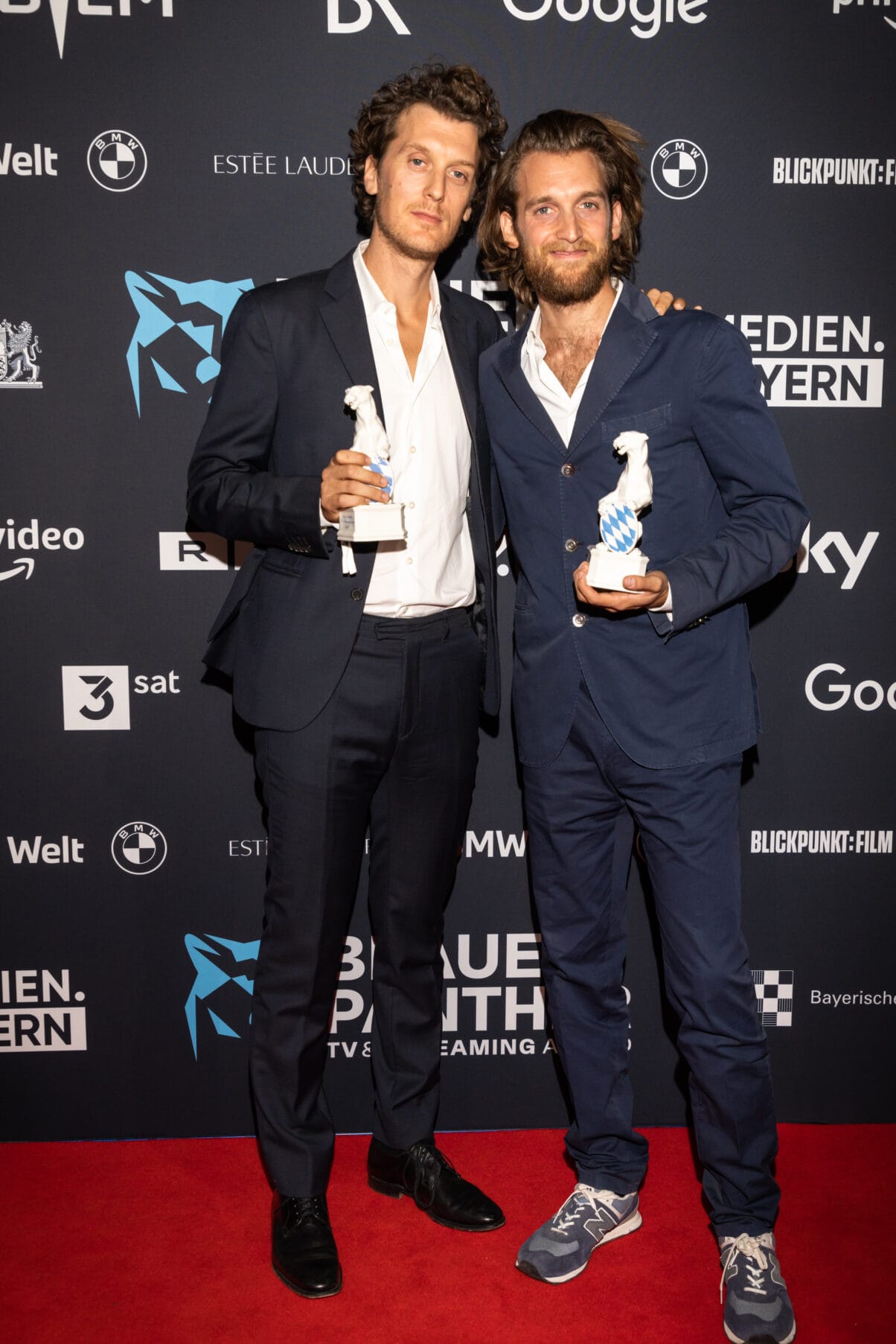 Benji und Jono Bergmann (c) Medien.Bayern Johannes Müller Benji und Jono Bergmann mit den Panther Statuen in der Hand vor der Pressewand 2022